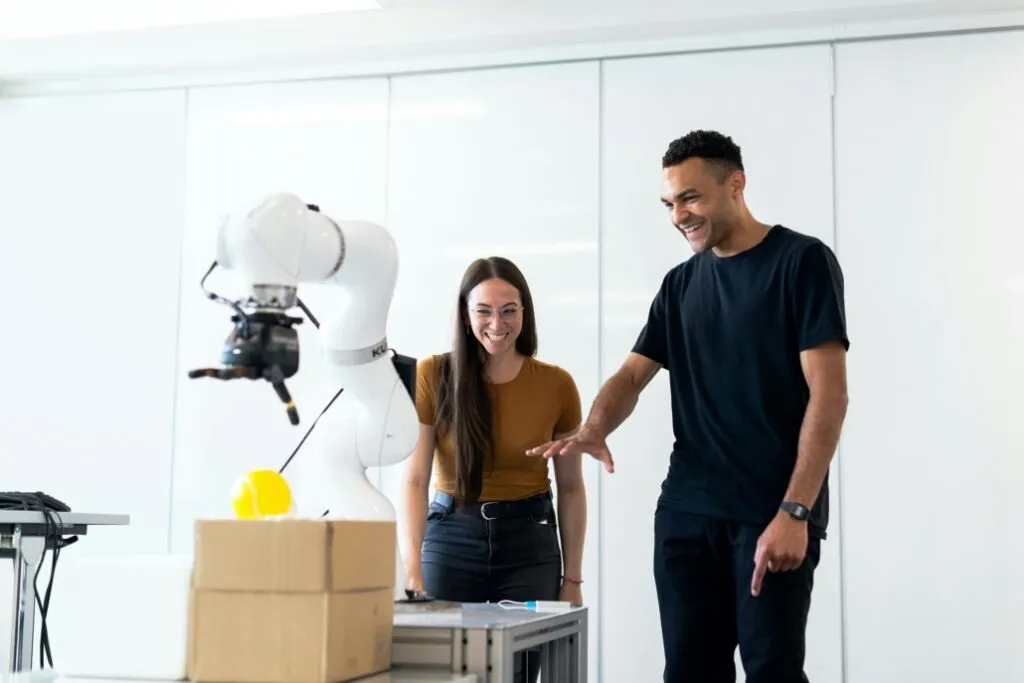 Un homme et une femme devant un bras robot