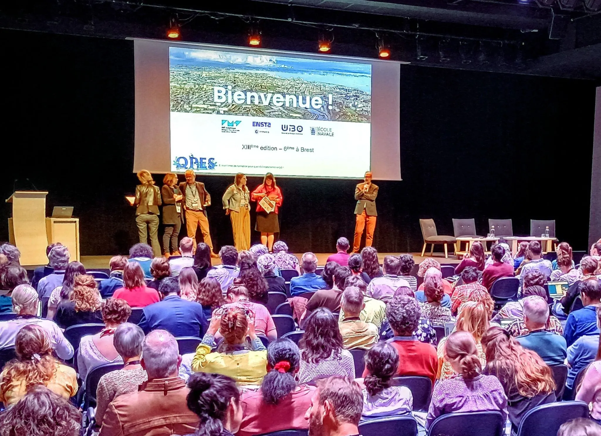 Photo du public regardant vers l'écran pendant le colloque QPES