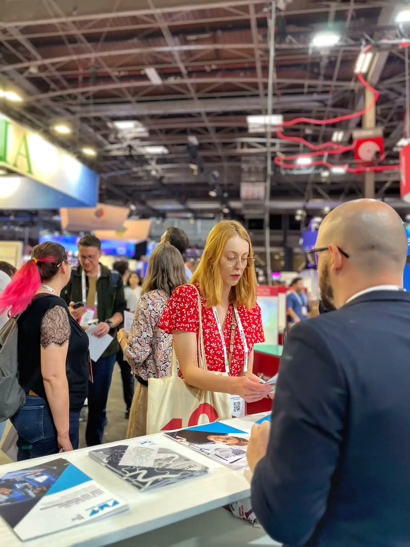 Photo de l'accueil du stand IMT sur le salon VivaTech lors d'un échange entre un membre de l'équipe et une étudiante
