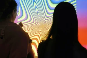 Deux filles de dos face à un décors psychédélique.