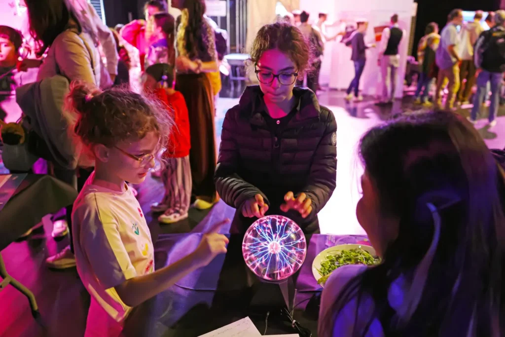 Trois enfants autour d'une animation scientifique.