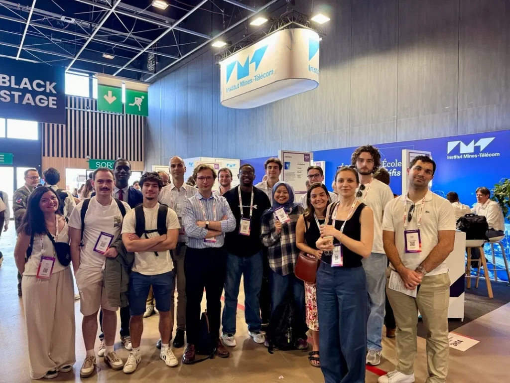 Photo de groupe devant le stand IMT.